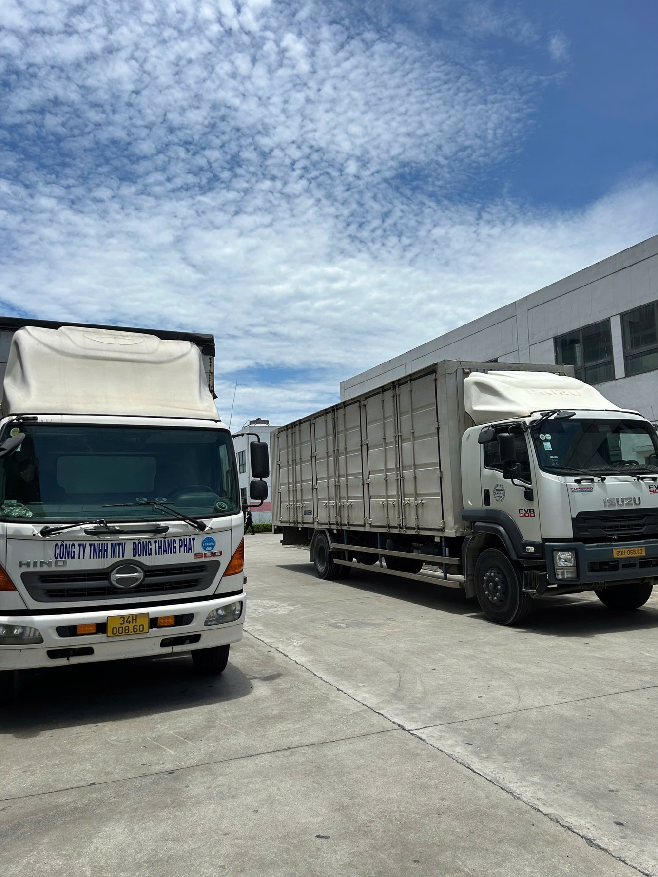 Hai xe tải chờ bốc dỡ tại sân kho